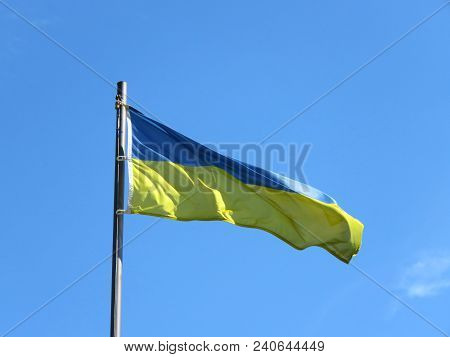 National Flag Of Ukraine On A Flagpole In Front Of Blue Sky.