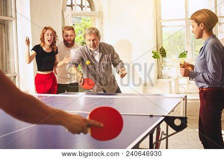 Group Of Happy Young Friends Playing Ping Pong Table Tennis At Office Or Any Room. Concept Of Health