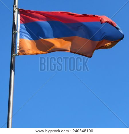 National Flag Of Armenia On A Flagpole In Front Of Blue Sky.