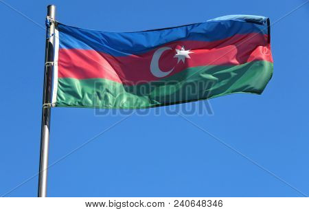 National Flag Of Azerbaijan On A Flagpole In Front Of Blue Sky.