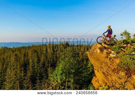 Mountain biking woman riding on bike in summer mountains forest landscape. Woman cycling MTB flow trail track. Outdoor sport activity.
