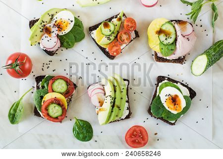 Different Sandwiches With Vegetables, Eggs, Avocado, Tomato, Rye Bread On Light Marble Table. Top Ve