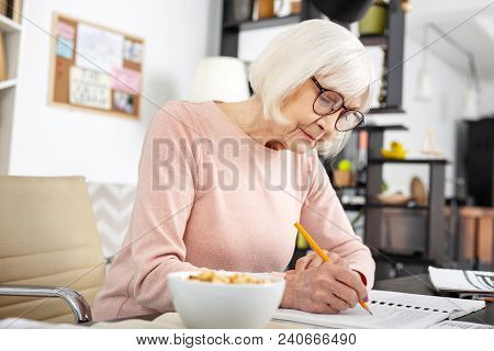More Practice. Confident Senior Woman Studying While Taking Notes