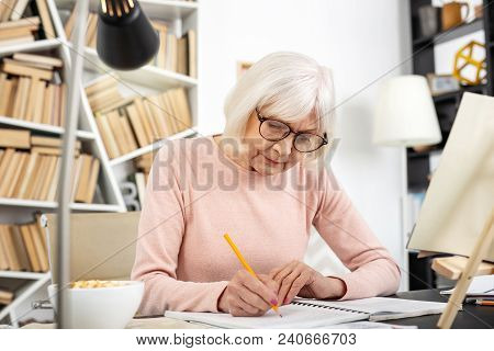 Be Attentive. Attractive Senior Woman Studying While Writing