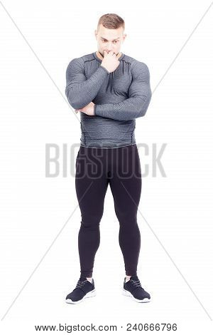 Portrait Of Handsome Well-muscled Gym Instructor In Sports Tights And Rashguard Posing On White Back