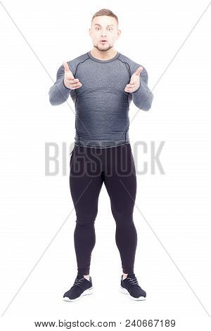 Portrait Of Handsome Well-muscled Gym Instructor In Sports Tights And Rashguard Posing On White Back