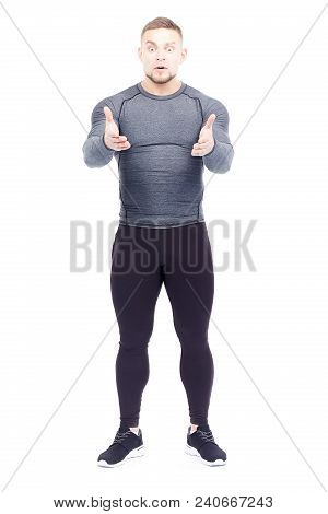 Portrait Of Handsome Well-muscled Gym Instructor In Sports Tights And Rashguard Posing On White Back