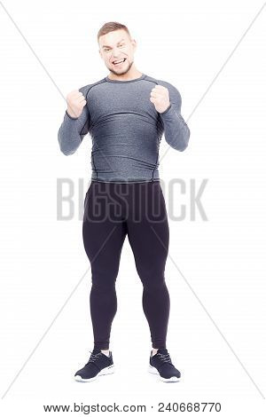 Portrait Of Handsome Well-muscled Gym Instructor In Sports Tights And Rashguard Posing On White Back