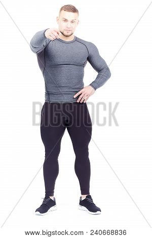 Portrait Of Handsome Well-muscled Gym Instructor In Sports Tights And Rashguard Posing On White Back