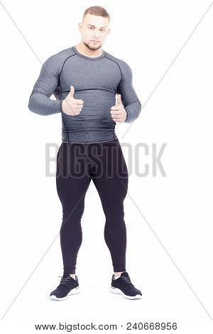 Portrait Of Handsome Well-muscled Gym Instructor In Sports Tights And Rashguard Posing On White Back