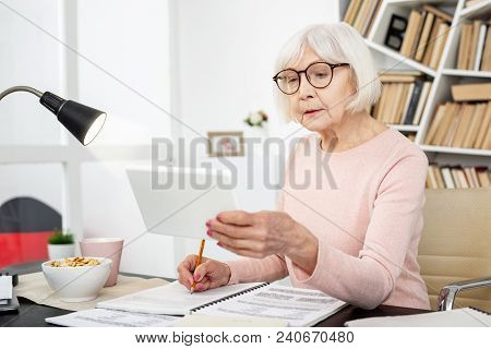 Education For Everyone. Thoughtful Senior Woman Using Tablet While Posing At Table