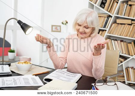 Easy Answer. Pleased Mature Woman Gesturing While Doing Task