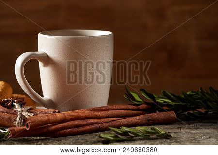 Traditional Christmas Tea Concept With A Cup Of Hot Tea Cinnamon Sticks Bunch, A Couple Of Dried Ora