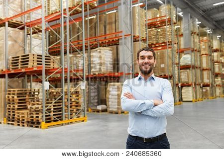 logistic business, shipment and people concept - happy businessman at warehouse