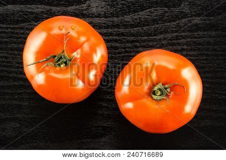 Two Red Tomato Isolated On Black Wood Background Top View