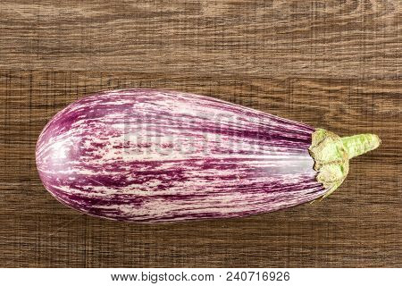 One Striped Purple Eggplant Top View Isolated On Brown Wood Background