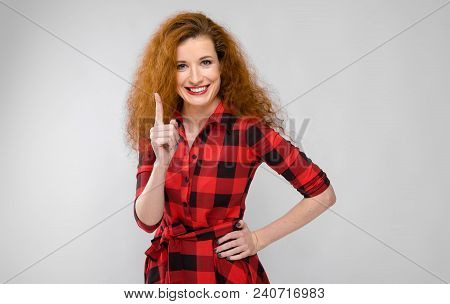 Charming Young Girl In A Checkered Cloth On A Gray Background