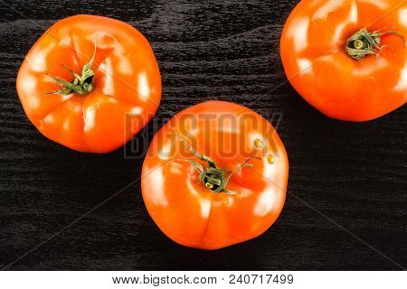 Three Red Tomato Isolated On Black Wood Background Top View