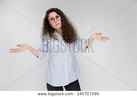 Young Girl With Glasses On A Gray Background. Portrait Of A Young Beautiful Girl. A Charming Girl In