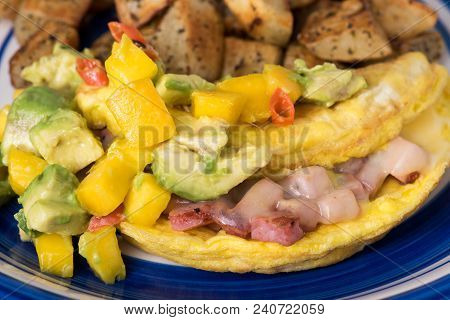 Ham And Swiss Cheese Omelette With Spicy Mango And Avacado Salsa And Pan Fried Hashbrown Potatoes