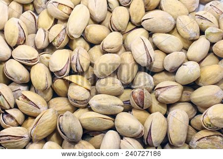 Big Set Of Salted Pistachios On The Table. Pistachios Nuts Macro Close Up Background Photo.