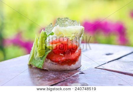 Melting Ice Cube With Strawberry, Lemon And Fresh Green Mint Leaves On Wooden Surface Outdoors