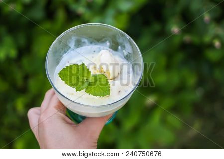 Icecream With Fresh Green Mint Leaves In A Transparent Vase In A Hand On Summer Nature Background.