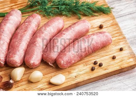Grilled Sausages, Garlic And Dill On A Wooden Cutting Board
