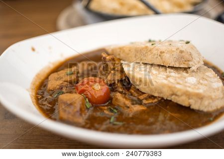 Traditional Goulash With Knedle In A White Bowl Of Beef Stew On The Wooden Table, Germany Menu