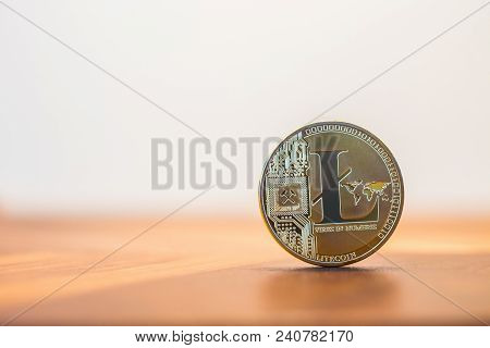 Cryptocurrency Electronic Money Sign, Focus On Metal Litecoin Stack On Wooden Table, Blur White Back