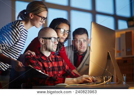Group of designers using computer for work. They are working till night