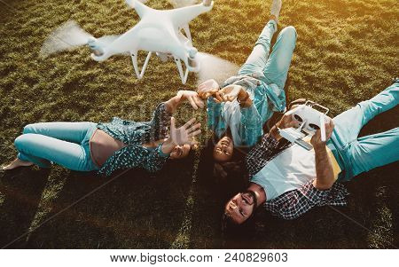 The Group Of Three Friends Of Different Race And Gender: Laying On The Summer Lawn And Recording A V