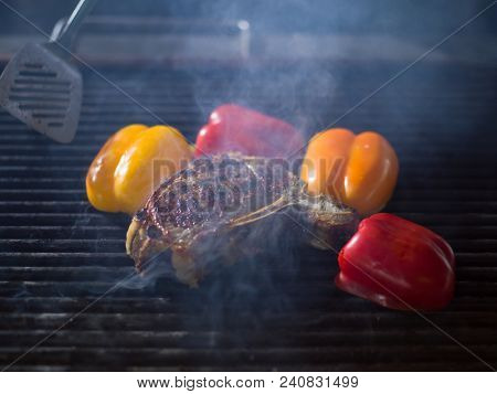 Master chef cooking delicious grilled meat steak with vegetables on a barbecue