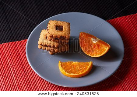 Chocolate Chip Cookies And Orange On Gray Plate And On Red With Black Table