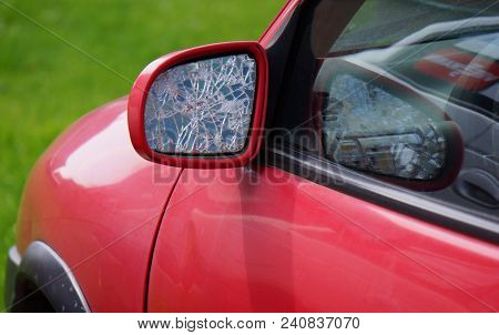Car With Broken Side Door Mirror. Red Car In Green Background. Asociative. Opel Corsa.