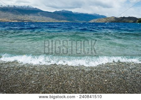 Coast of the lake of Cochrane with clear blue water. Focus on the wave on foreground. Patagonia, Chile