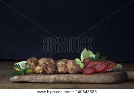 Breaded Chicken Meat With Salad And Lemon Resting On A Rustic Wooden Board
