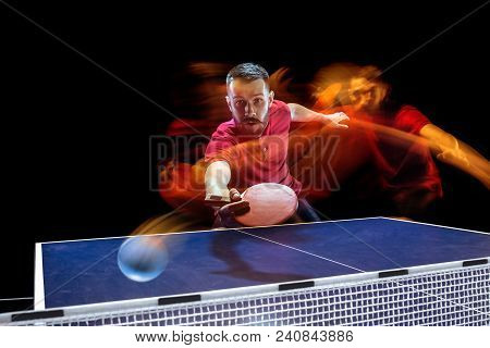 The Table Tennis Player In Motion. Fit Young Sports Man Tennis-player In Play On Black Background Wi