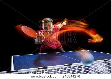 The Table Tennis Player In Motion. Fit Young Sports Man Tennis-player In Play On Black Background Wi