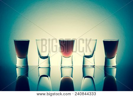 Small Glasses With A Drink Shots Of Alcohol Stainding In A Table With Reflection