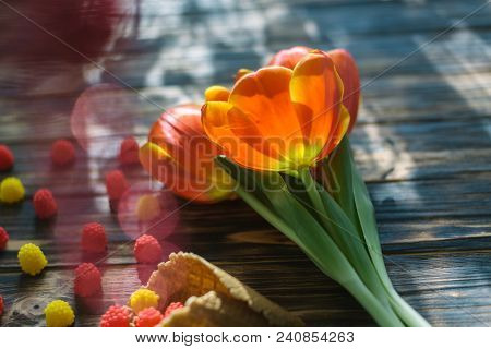 Blossoming Red Tulips On A Wooden Background With Sweets