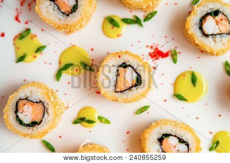 Close Up Delicious Sushi Rolls Put On White Surface With Drops Of Sauce And Caviar