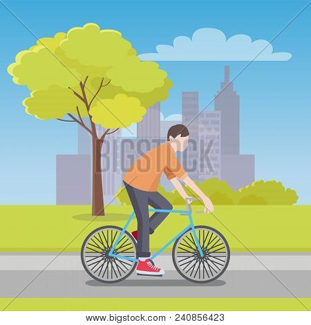 Man Rides Bicycle Along Road With City Skyscrapers On Horizon, Fresh Grass On Both Sides, Tall Tree 