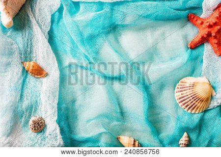 Several Seashells And Bright Red Starfish On Cian Cloth Background. Summer Holiday Concept