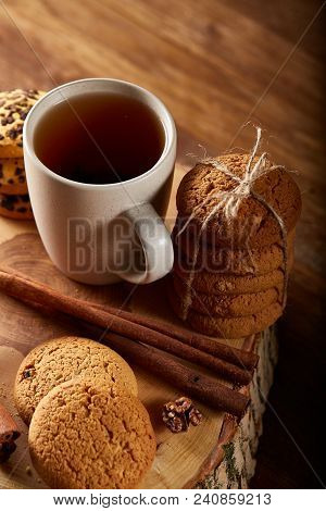 Christmas Concept With A Cup Of Hot Tea, A Large Set Of Cookies On A Homespun Napkin, Cinnamon Stick