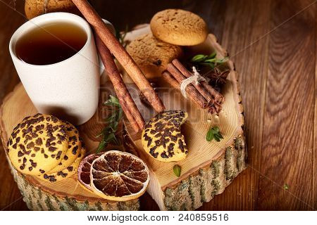Christmas Concept With A Cup Of Hot Tea, A Large Set Of Cookies On A Homespun Napkin, Cinnamon Stick
