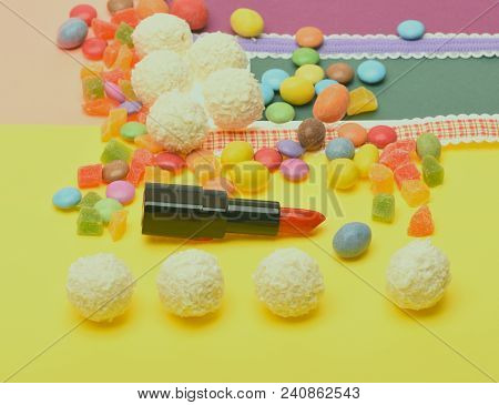 Smell And Taste Of Lipstick Concept. Red Or Scarlet Lipstick On Yellow Background Near Colorful Drag