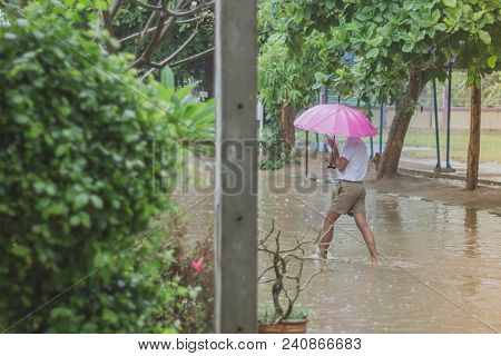 Students Walk To The Flood After Rain In School.