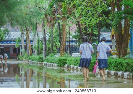 Students Walk To The Flood After Rain In School.