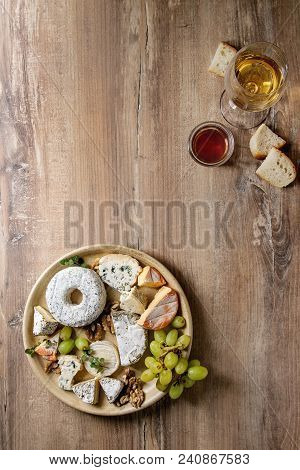 Cheese Plate Assortment Of French Cheese Served With Honey, Walnuts, Bread And Grapes On Ceramic Pla
